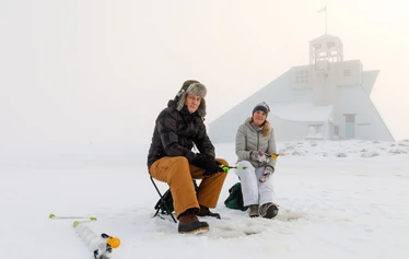 Ice fishing on the frozen sea in Oulu