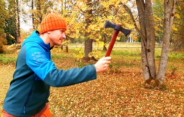 The primal games | Team activity | FoRestful - A participant in a primitive games activity lighting a fire using a fire striker.