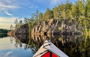 Kajakki lipuu järvellä Repovedellä. - Kajakki lipuu peilityynellä järvellä Repovedellä.