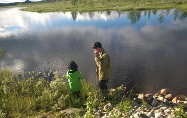 Angler catching a northern pike on a private river expedition in Molkojärvi, Lapland