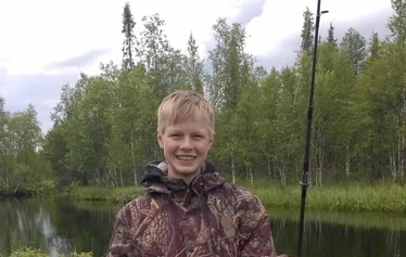Angler catching a northern pike on a private river expedition in Molkojärvi, Lapland