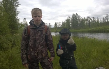 Angler catching a northern pike on a private river expedition in Molkojärvi, Lapland
