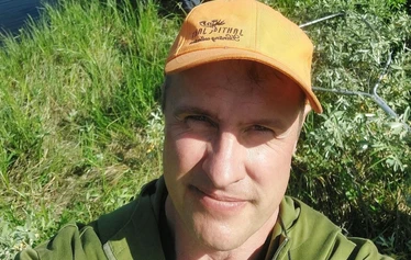 Angler catching a northern pike on a private river expedition in Molkojärvi, Lapland