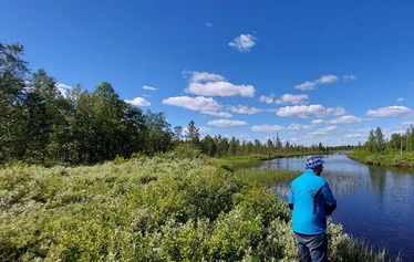Angler catching a northern pike on a private river expedition in Molkojärvi, Lapland