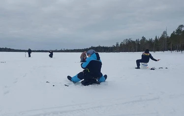 A private wood-fired sauna and an ice fishing hole on a frozen lake in Molkojärvi, Lapland