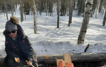 A private wood-fired sauna and an ice fishing hole on a frozen lake in Molkojärvi, Lapland