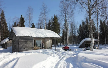 A private wood-fired sauna and an ice fishing hole on a frozen lake in Molkojärvi, Lapland