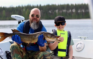 Hauki ja tyytyväinen asiakas - Kalastusretki Puumalassa on hieno luontoelämys. Hyvällä tuurilla nappaat retkellä elämäsi kalan, kuten nuori asiakas tässä
