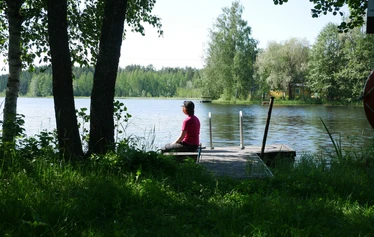 Nainen istuu laiturilla