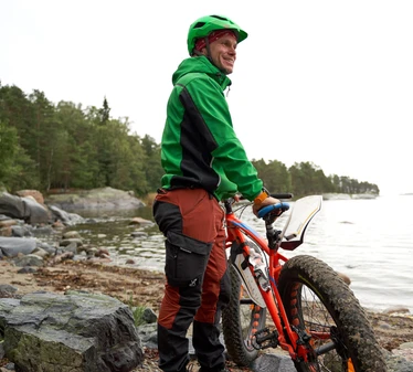 Fatbike-pyöräilyä - Mies fatbike-pyörän kanssa merenrannalla