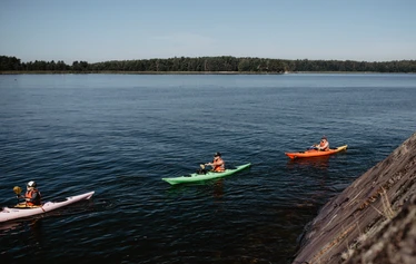 Beginner course in kayaking - Kayakers paddling in a group, exploring the Helsinki archipelago from Vuosaari Paddling Center