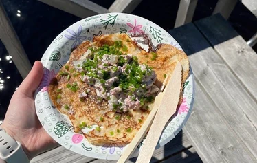 Lettubaarin juhannusjuhla vuodelta 2021 - Harri Kautonen musisoi ja kansa nauttii baarin antimista.