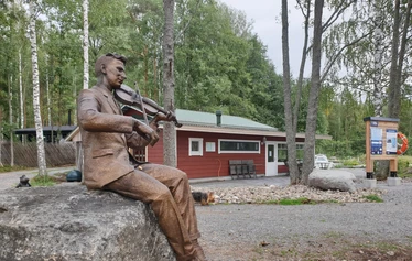 Lettubaarin juhannusjuhla vuodelta 2021 - Harri Kautonen musisoi ja kansa nauttii baarin antimista.