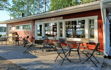 Lettubaarin juhannusjuhla vuodelta 2021 - Harri Kautonen musisoi ja kansa nauttii baarin antimista.