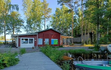 Lettubaarin juhannusjuhla vuodelta 2021 - Harri Kautonen musisoi ja kansa nauttii baarin antimista.