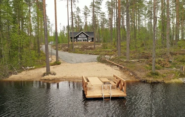 Hiili kuvattuna rannasta päin. - Pohjois-Savossa, Sonkajärven Jyrkän kylällä sijaitsevalla Hiili-loma-asunnolla on iso piha ja terassi, jossa pöytäryhmä 8:lle ja kaasugrilli (kesällä) .