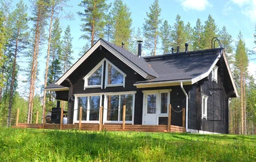 Miilu kuvattuna rannasta päin. - Pohjois-Savossa, Sonkajärven Jyrkän kylällä sijaitsevan Miilu mökin iso terassi, jossa pöytäryhmä 8:lle, kaasugrilli (kesällä) ja  nurmikkoinen takapiha.