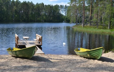 Hiili kuvattuna rannasta päin. - Sonkajärven Jyrkän kylällä sijaitsevalla Hiili-loma-asunnolla on iso terassi, jossa pöytäryhmä 8:lle, kaasugrilli ja iso nurmikkoinen takapiha