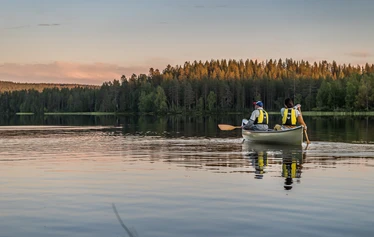 Yömelonta Syötteellä - Kesän yötön yö ja kaksi ihmistä melomassa kanootilla järvimaisemassa