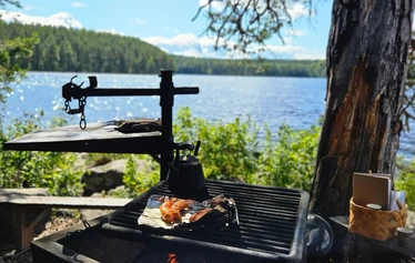 Nuotiohetki järvimaisemassa Mäntyharjulla - Retken kohokohta on kiireetön nuotiohetki järven rannalla. Nuotion äärellä nautitaan makkaraa, nokipannukahvia ja Mäntyharjun luonnon rauhasta.